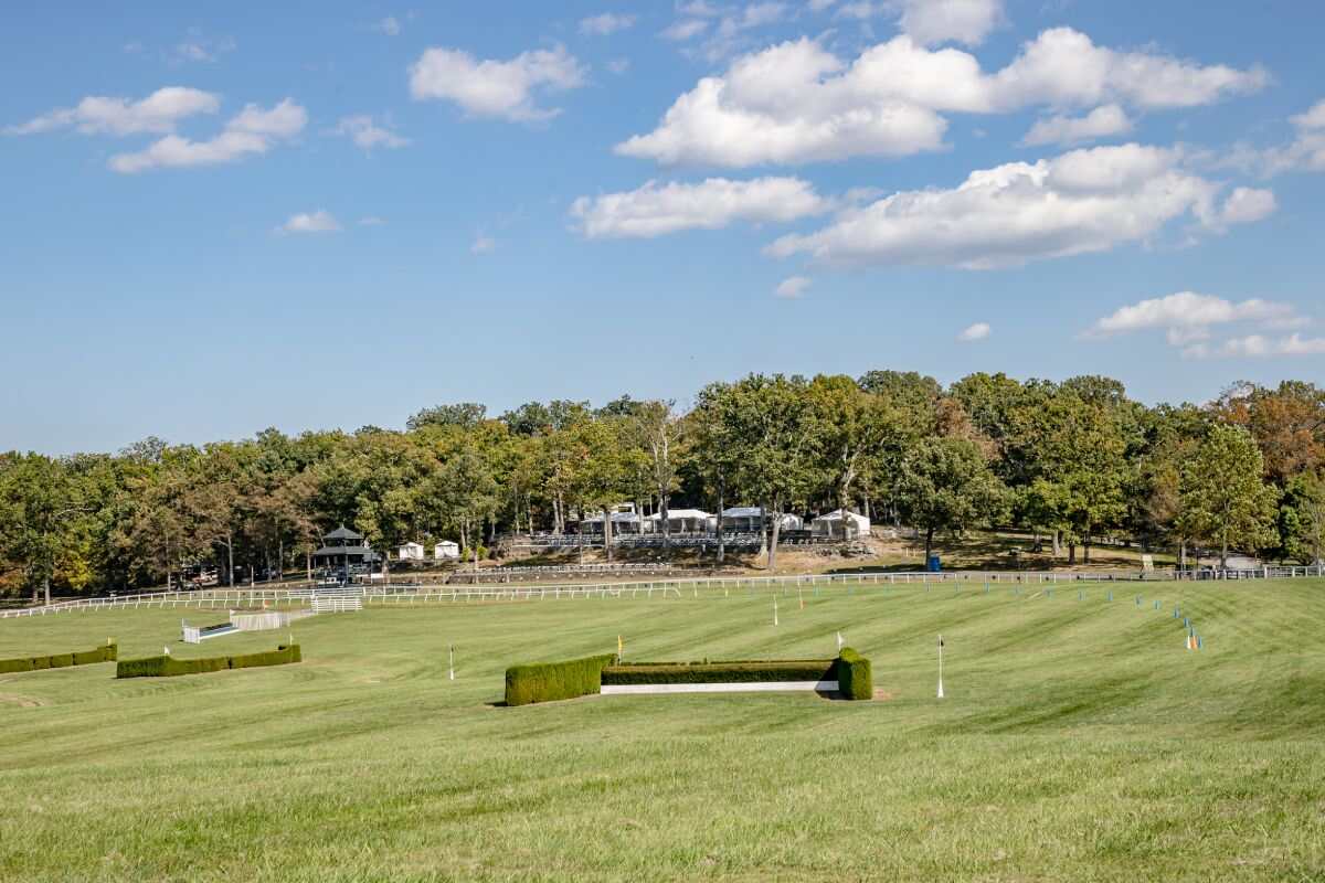 panoramic view of steeplechase course with tents in background