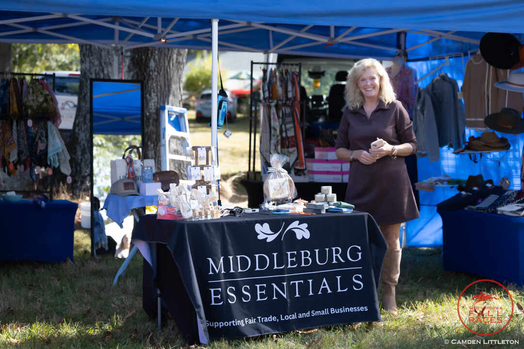 Woman standing next to sign for Middleburg Essentials